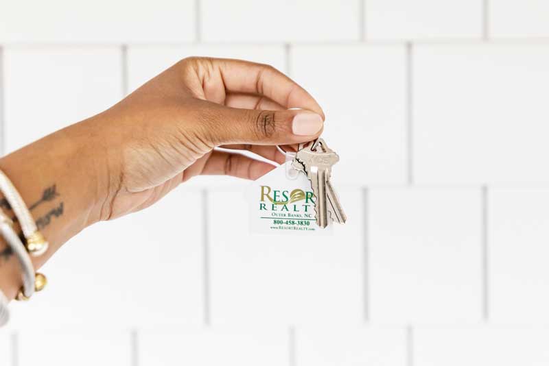 Hand holding keys to your Resort Realty Outer Banks vacation rental. 
